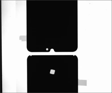 Source example A under the white LS-HFS200150: dark film shapes have visible small punched openings and edge notches.