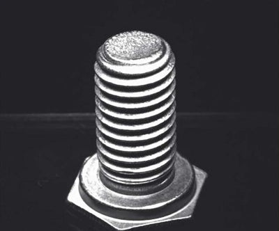 Source capture of a hex bolt standing on its head under a blue ring light: bright thread crests, dark roots and the end face on top. Complete capture inside the brochure frame, not retouched.