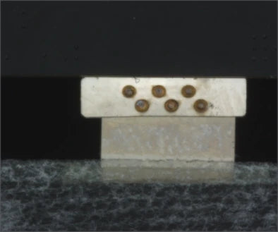 Source colour capture of six round solder joints on the face of an electrode block under a white flat coaxial light. Complete capture, not retouched.