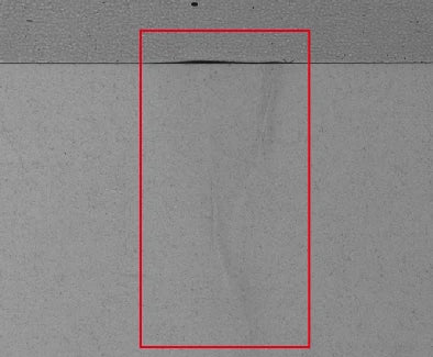 Conventional line-light capture of the label application; original red box retained.