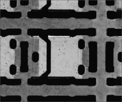 Independent source example B under the white LS-CXL-0185: substrate paths and openings are visible. These are different samples, not a before-and-after pair.