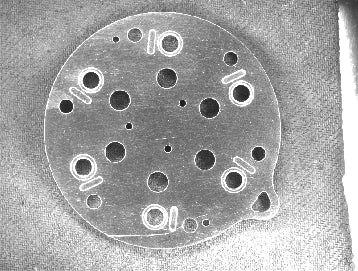 Camera capture with the white LS-BAR-0706: scratches and hole rims return brighter than the surrounding surface.