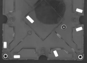Reviewed source crop: several bright rectangular regions and moulded carrier features remain visible. Upper moulded branding is excluded.