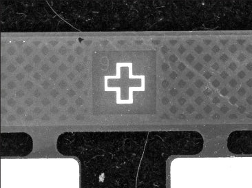 The reference cross is bright against the textured board region in the supplied capture.