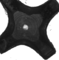 Reviewed source centre crop: a bright local region is visible within the darker recessed part. Unrelated background markings are outside the crop.