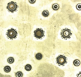 Source colour capture of a metal server panel under a white panel light: screws with toothed lock washers and smaller six-lobe screws. Cropped at the left edge to remove stamped letters; not retouched.