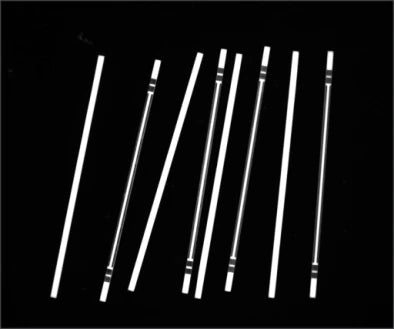 Source polarized-light capture showing slender metal parts with differing bright end and shoulder features.