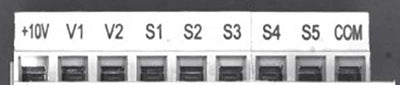 Source monochrome capture of the upper row of a terminal block under a white shadowless ring light: legends +10V, V1, V2, S1 to S5 and COM above nine openings. Cropped to the upper row; not retouched.